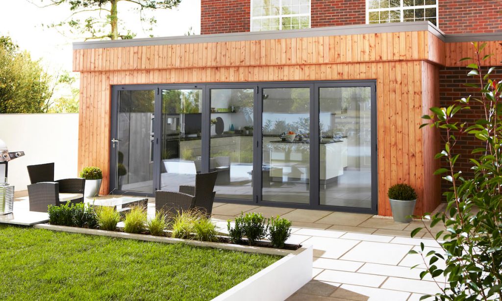 Exterior view of Origin aluminium bifold doors opening to a garden, providing a seamless connection to outdoor living areas, perfect for homes in {location}.