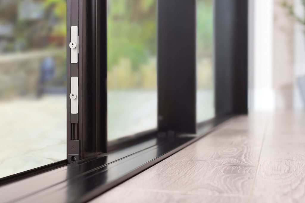 Close-up of the Origin aluminium sliding door lock mechanism and track, demonstrating its smooth operation and secure design, perfect for homes in {location}.